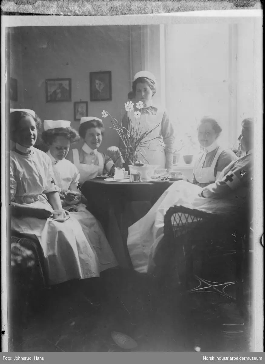 Gruppe med sykepleiere rundt et dekket bord.