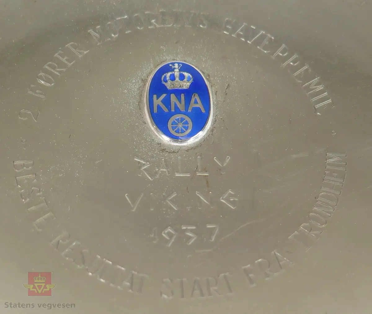 Fire pokaler, (to ulike størrelser) og ett fat i sølvplett. Alle fem har logo fra KNA samt inskripsjon som forteller om hva premien er udelt for.