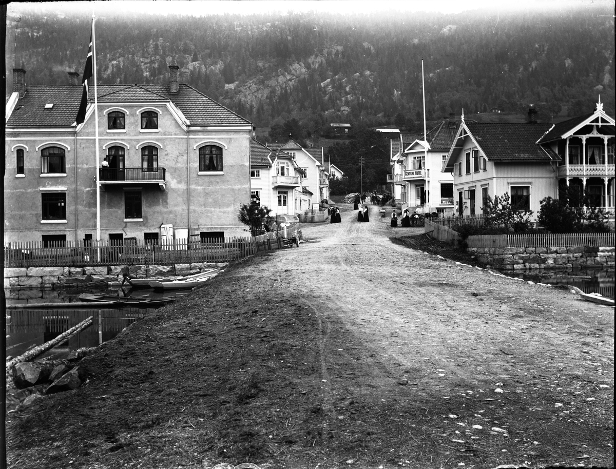 Fotosamling etter Kjetil Skomdal (1881-1971). Fotografen virket i perioden 1910 til 1960 og hadde eget mørkerom hvor han også tok imot film fra andre fotografer. I perioden var han også postbud i Fyresdal. Gateparti fra Kviteseid.