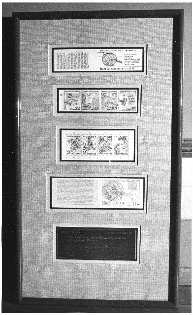 En inglasad tavla visar dagens samutgåva - de amerikanska och
svenska frimärks-häftena till utställningen Stockholmia 86 IV.