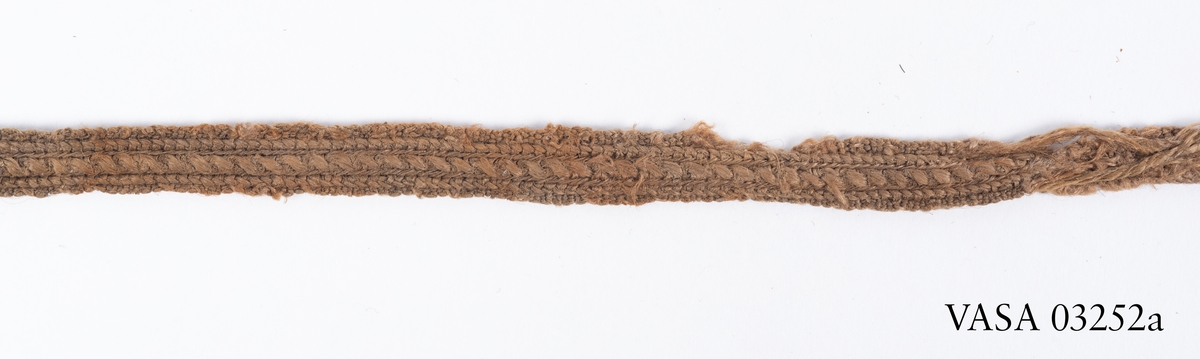 Textilier. 
14 textilfragment uppdelade på fyndnummer 03252a-d.
Fnr 03252a är ett silkesband. 
Fnr 03252b är ett textilfragment av ull vävt i tuskaft. 
Fnr 03252c består av 10 fragment av ull vävda i tuskaft. Flera av fragmenten har bevarade originalkanter med sömmar.
Fnr 03252d består av två fragment av ull vävda i tuskaft.