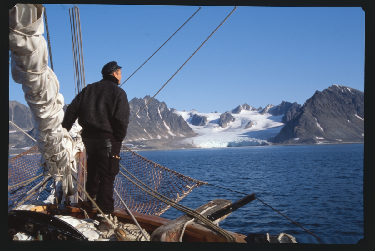 Mann står i baugen på "Anna Rogde", isbre i bakgrunnen.