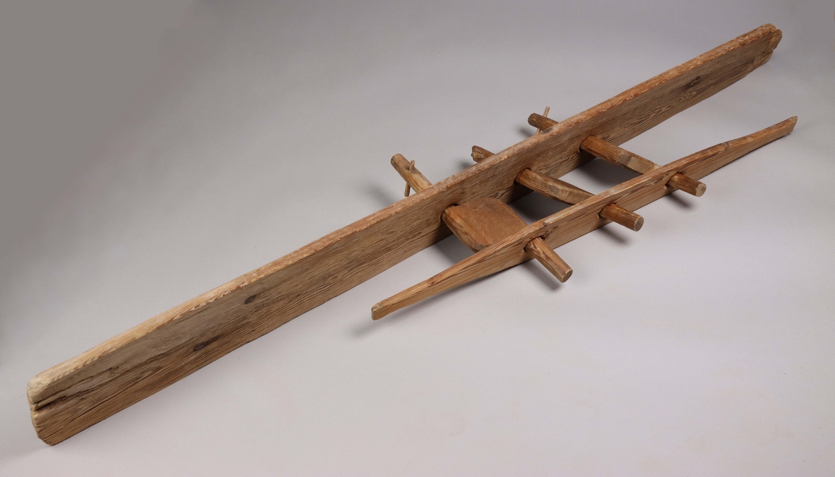 A wooden strand twister, one part of a rope twister maschine made for twisting three strands into a rope.  It consists of five parts, one tall board with drilled holes, three wooden turning wings and one shorter board with handles at each end. The two boards have drilled holes that keeps the wooden wings attached to the boards