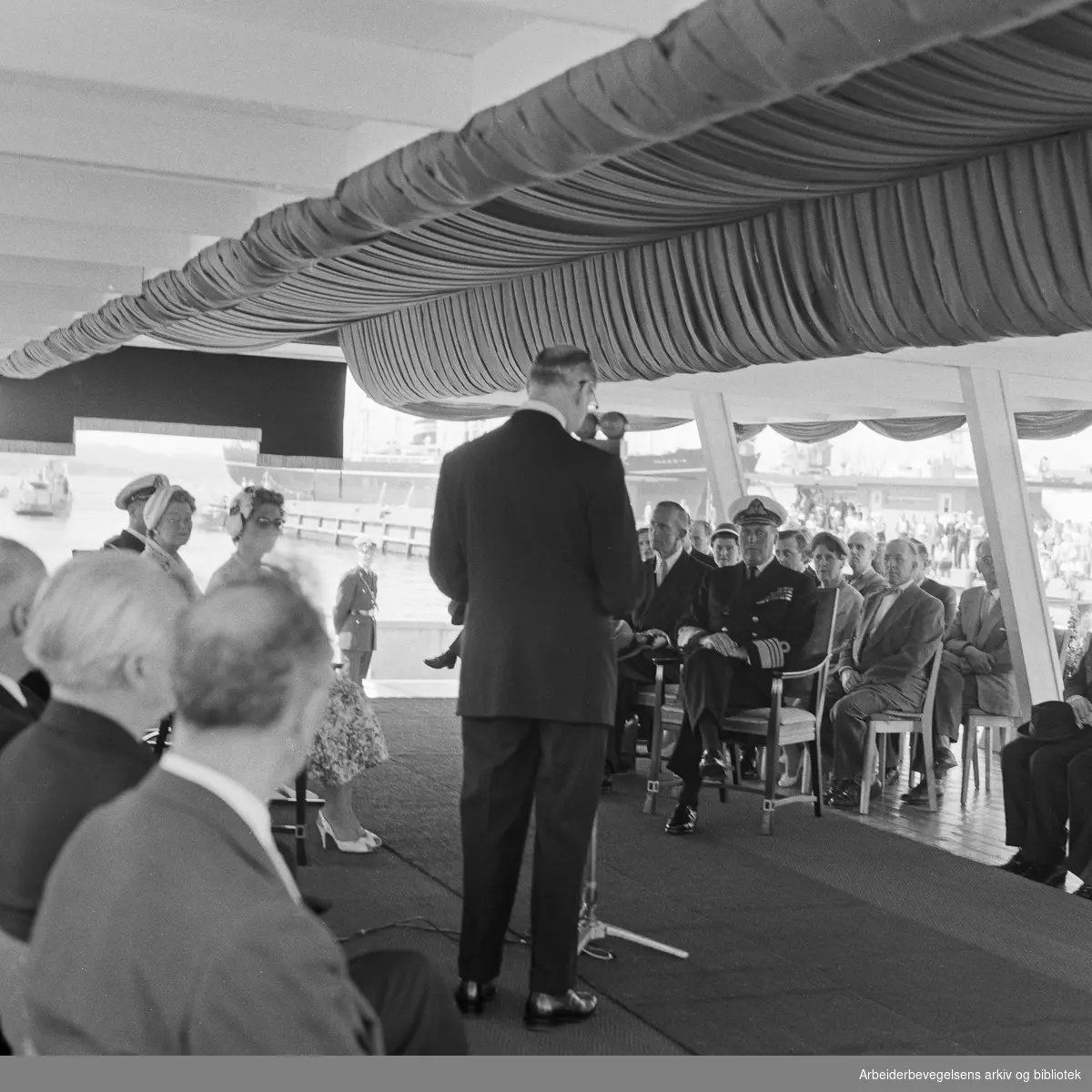 Kong Olav V og prinsesse Astrid ankommer Oslo etter signingsferden. Ordfører Rolf Stranger holder velkomsttalen på Rådhuskaia. Juli 1958.