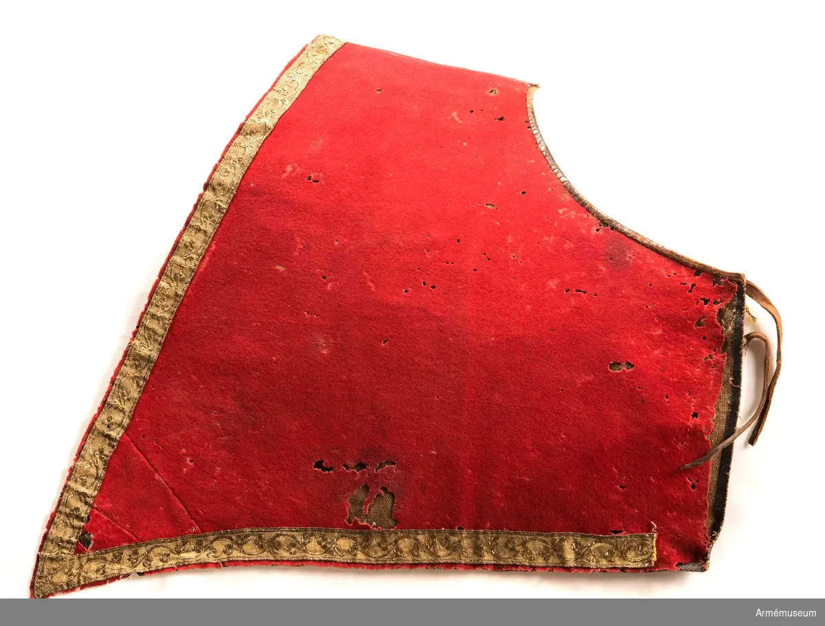 Schabrak av rött kläde med bård av guldgalon.