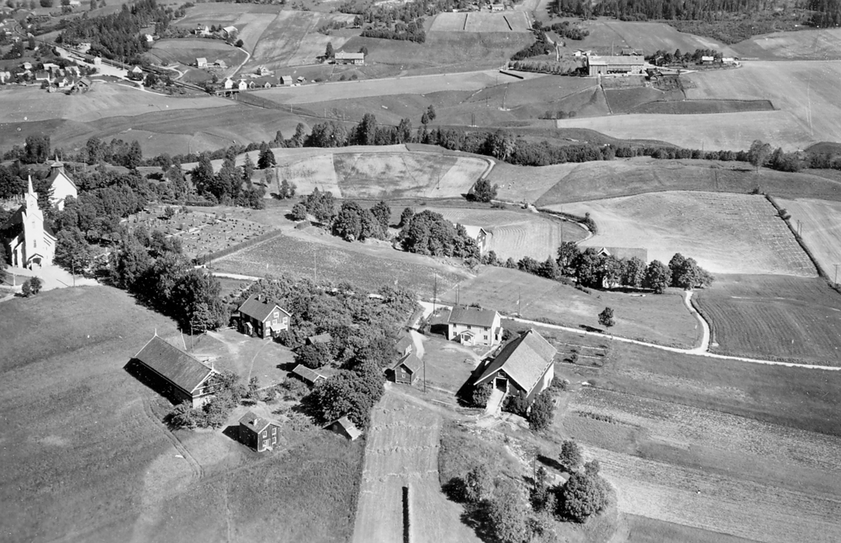 Flyfoto av Bøhaugen med kyrkjene og Bø-gardane (Midt-Bø), tatt 5. juli 1952.