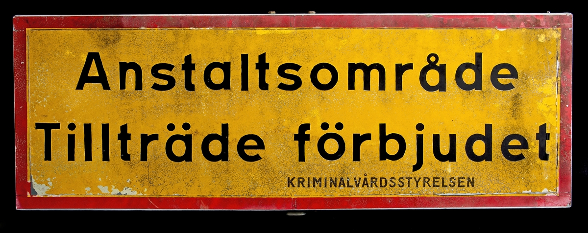 Vägskylt, gulröd med "Anstaltsområde Tillträde förbjudet Kriminalvårdsstyrelsen".
