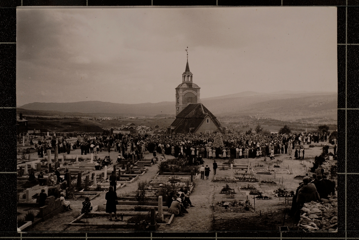 Øvre kirkegård og kirka på Røros. En stor folkemengde er samlet på øvre kirkegård i forbindelse med avduking av minneplaten på bergmannsminnesmerket 21. juli 1946