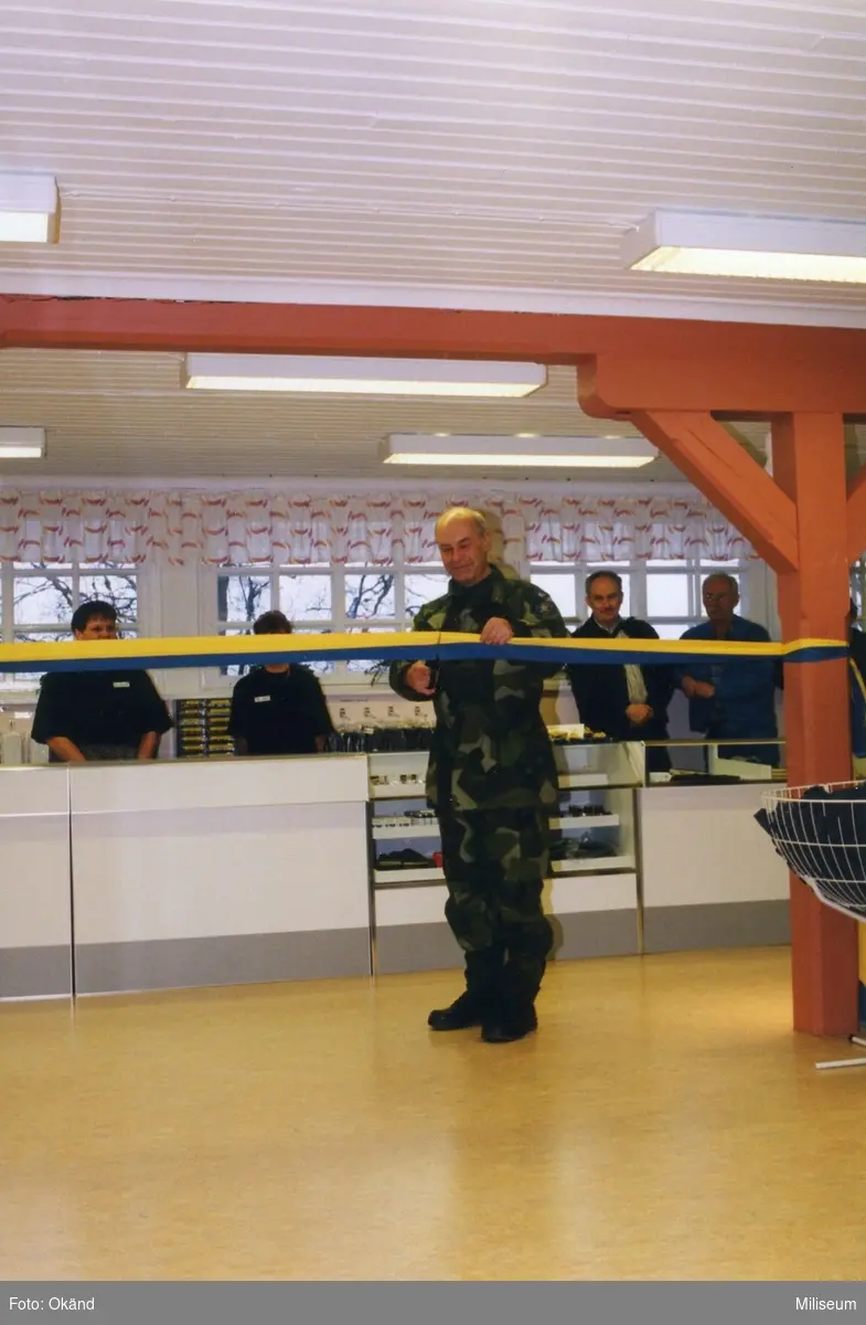 Invigning av personalbutik UFFE/90 (Uniformsförsäljning för enskilda modell 90).

Chefen I 12/Fo 17 överste Wilhem Af Donner klipper det blågula invigningsbandet. 

i bakgrunden Rody Andersson, Anita Sjöberg och Tomas Delaveaux och okänd.