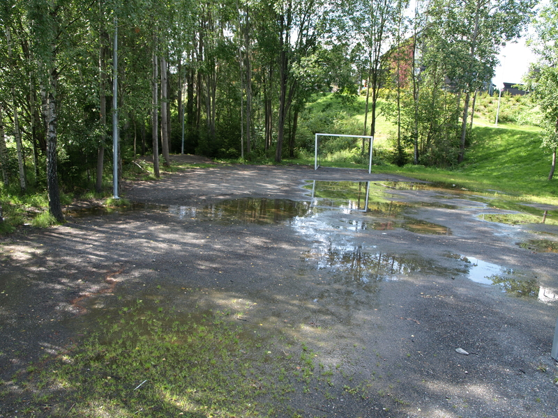 Den lille fotballbanen har erstattet gressletta ved veikrysset hvor leirplassen lå. Foto: Bodil Andersson, Østfoldmuseene - Halden historiske Samlinger. (2009)