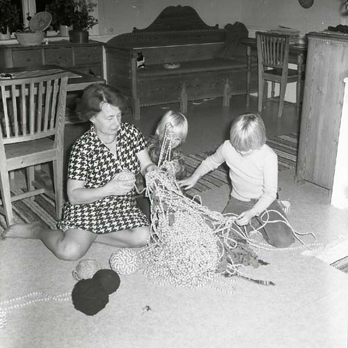 Hemma i Sunnanåker, mellan 1975-1977. Adéle nystar mattrasor tillsammans med två av barnbarnen.