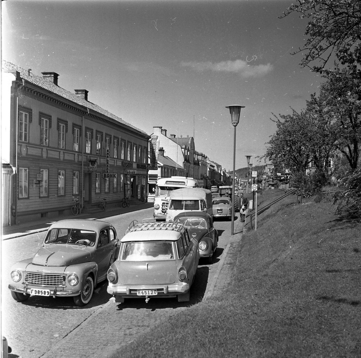 Vy över Brahegatan, i blickfånget är huset på Brahegatan 39 "Nordstedtska huset" som på 1960-talet inhyste Grännas postkontor, bank och speceriaffär. Längst med Brahegatan står bilar parkerade. En buss är på väg söderut med texten Jönköping på.