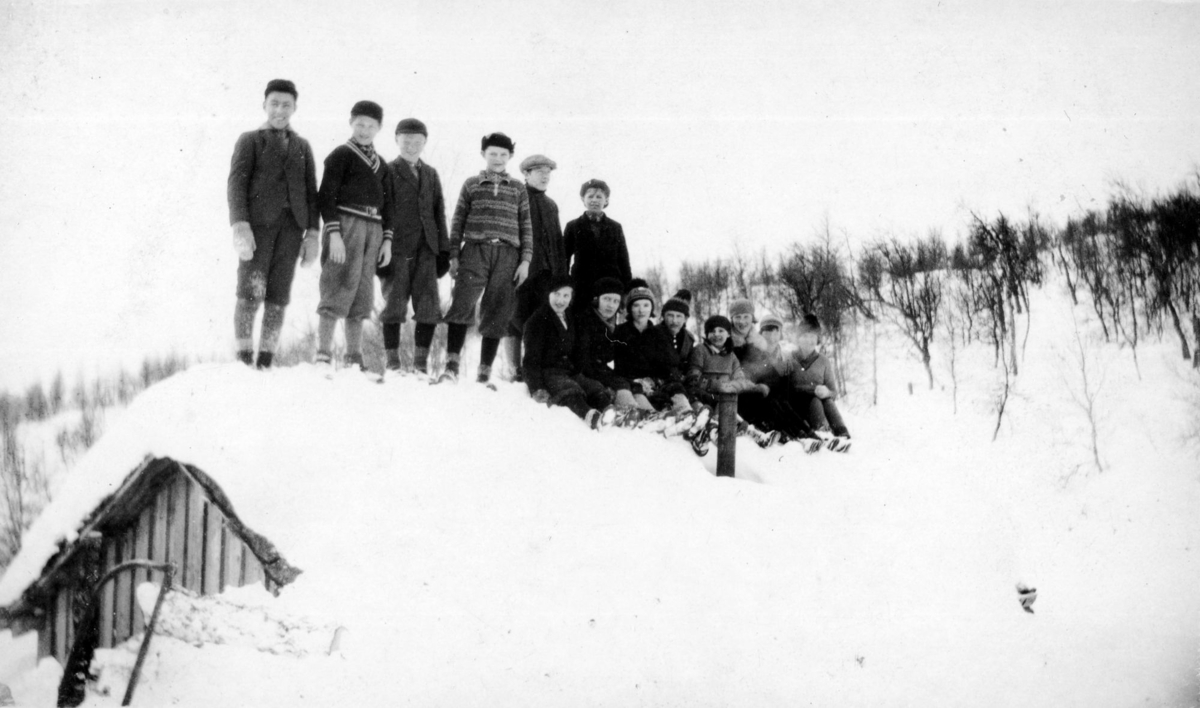 Gruppebilde på taket av setra en snørik vinterdag i 1934. Skoleskitur til Fjellro, Grønnkampen.