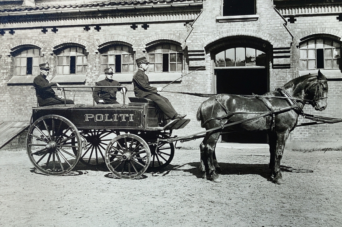 Tre politimenn på kjerre trukket av to hester.