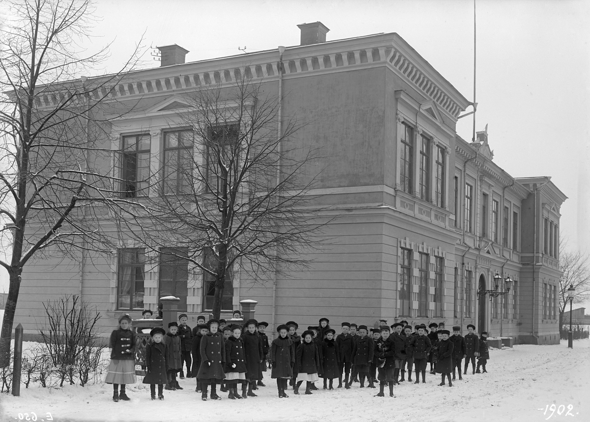 Vy mot Linköpings elementarläroverk för flickor en disig vinterdag 1902. Byggnaden uppfördes 1883 och löste då lokalfrågan för flickors högre utbildning i staden, som sedan 1867 var beslutad och från 1868 en realitet men tills nu varit husvill. För skolans ritningar stod den välrenommerade stockholmsarkitekten Axel Kumlien, som vid sidan av tio lärosalar skapade plats för gymnatik, bibliotek och bostad för skolans föreståndare samt rum för städerska. Skolan kom under 1940-talet ges nytt namn i Elsa Brändströms skola, själv elev på skolan vid tiden för bilden.