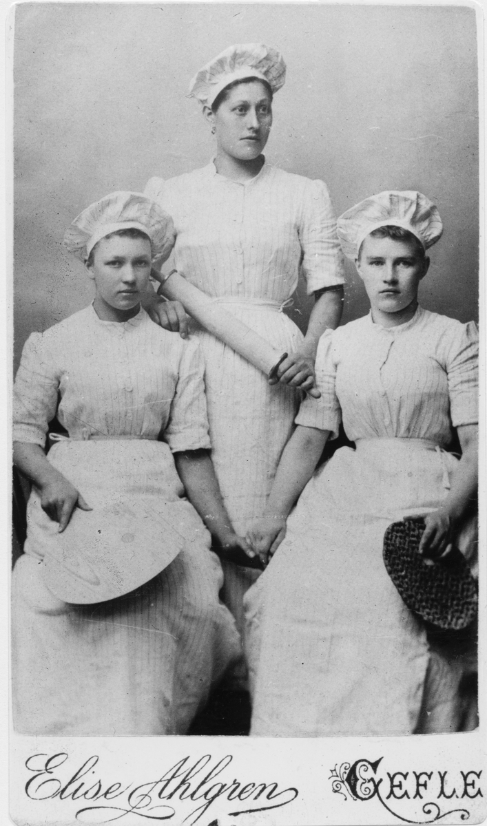 Tre flickor klädda som bagerskor.