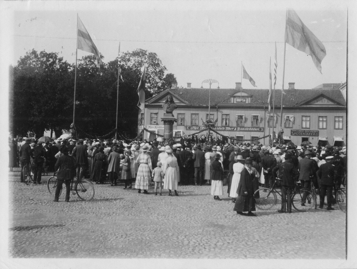 En folksamling på Stora Torget i Alingsås. Amerikanska flaggan syns och troligen pågår firandet i samband med Svenska Chicago-körens turné genom Sverige 1920.
