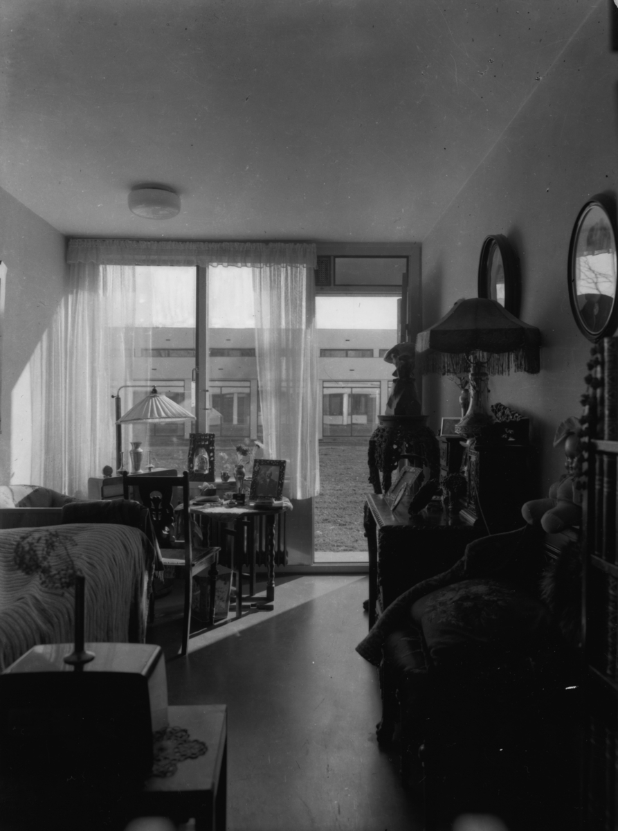 Arkitekturfoto av Økern Aldershjem. Arkitektene Fehn og Grung fikk i 1961 Houens fonds diplom for sin tegning av bygningen. Interiørbilde av stue.