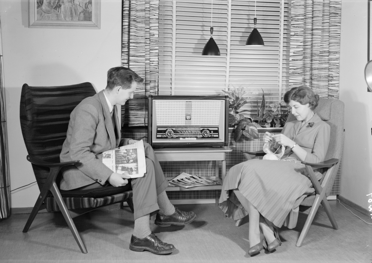 Reklamefoto av et par som sitter i stua og lytter til radio.