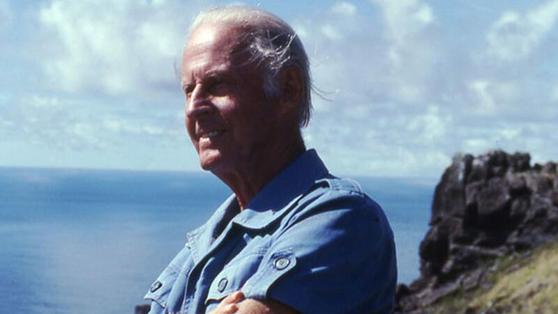 Bilde av Thor Heyerdahl i lyseblå kortermet skjorte. Han smiler og ser mot venstre.