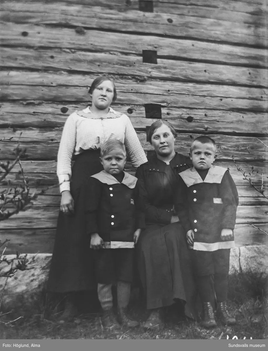 Familjeporträtt med en kvinna, en flicka och två små pojkar.