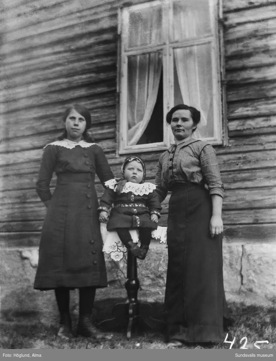 Porträttbild med en kvinna, en flicka och ett litet barn.