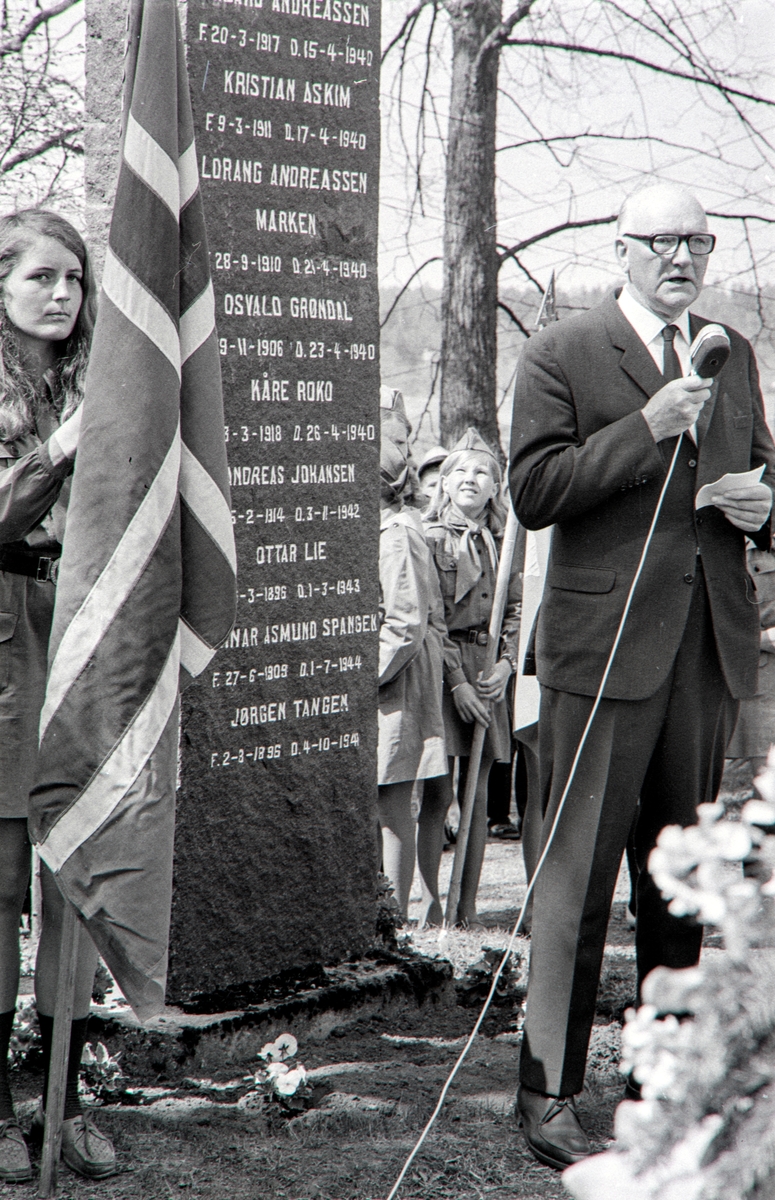 17. Mai feiring i Løten.
3 festkledde barn med norske flagg, Jørund Krogsrud, Randi Brendbekken og Endre Krogsrud. 
Den tidligere stortingsmannen Emil Løvlien holder tale, og legger ned blomster ved minnesmerket over de fallene i 2. verdenskrig i Løten.

