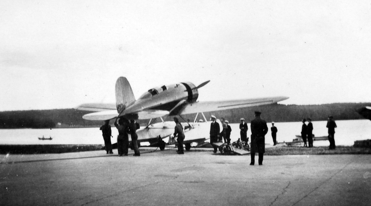 Flytt av flygplan Lockheed 8 Sirius ''Tingmissartoq' vid kaj på F 2 Hägernäs vid Charles Lindberghs besök i september 1933. Mekaniker i arbete. Vy snett bakifrån.