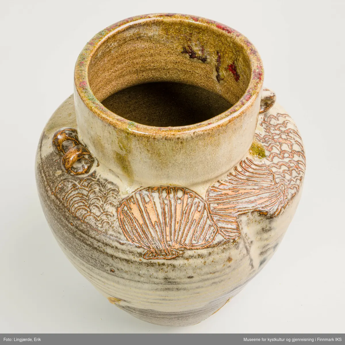 Krukken er utført i askeglasert keramikk. Overflaten består av en miks av jordtoner og forskjellige strukturelementer.