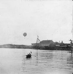 Robåt foran Akers Mek, luftballong i bakgrunnen. Fra Cettis 