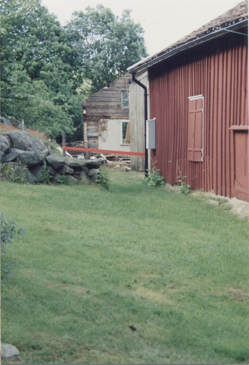 I bakgrunden till vänster ses rivningen av boningshuset Långåker 1:2 cirka 2000. En del av gaveln och ytterväggar ingår i det nya huset. Det röda huset till höger är hembygdsgården Långåker 1:3.
