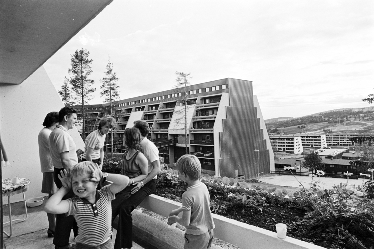 Voksne og barn står på terrasse på Vestlifeltet.