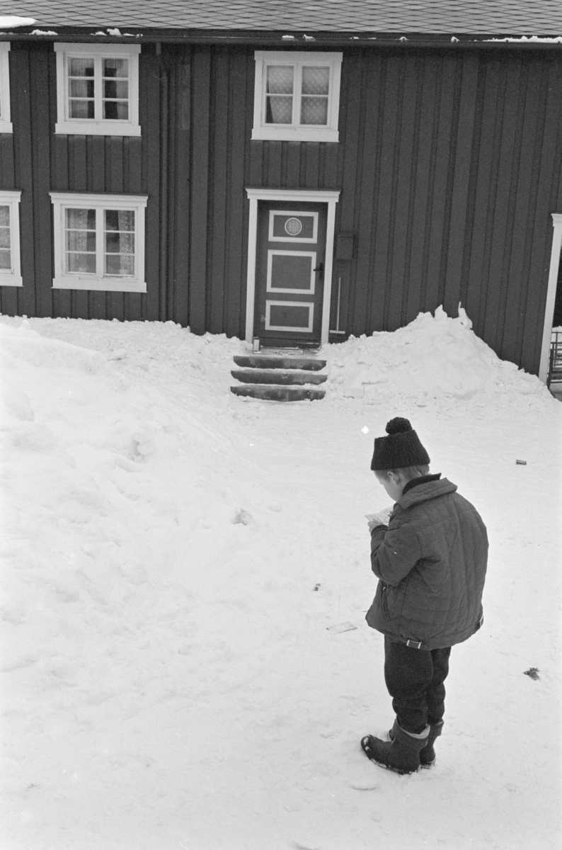 Et barn i snøen foran et bolighus på Røros.