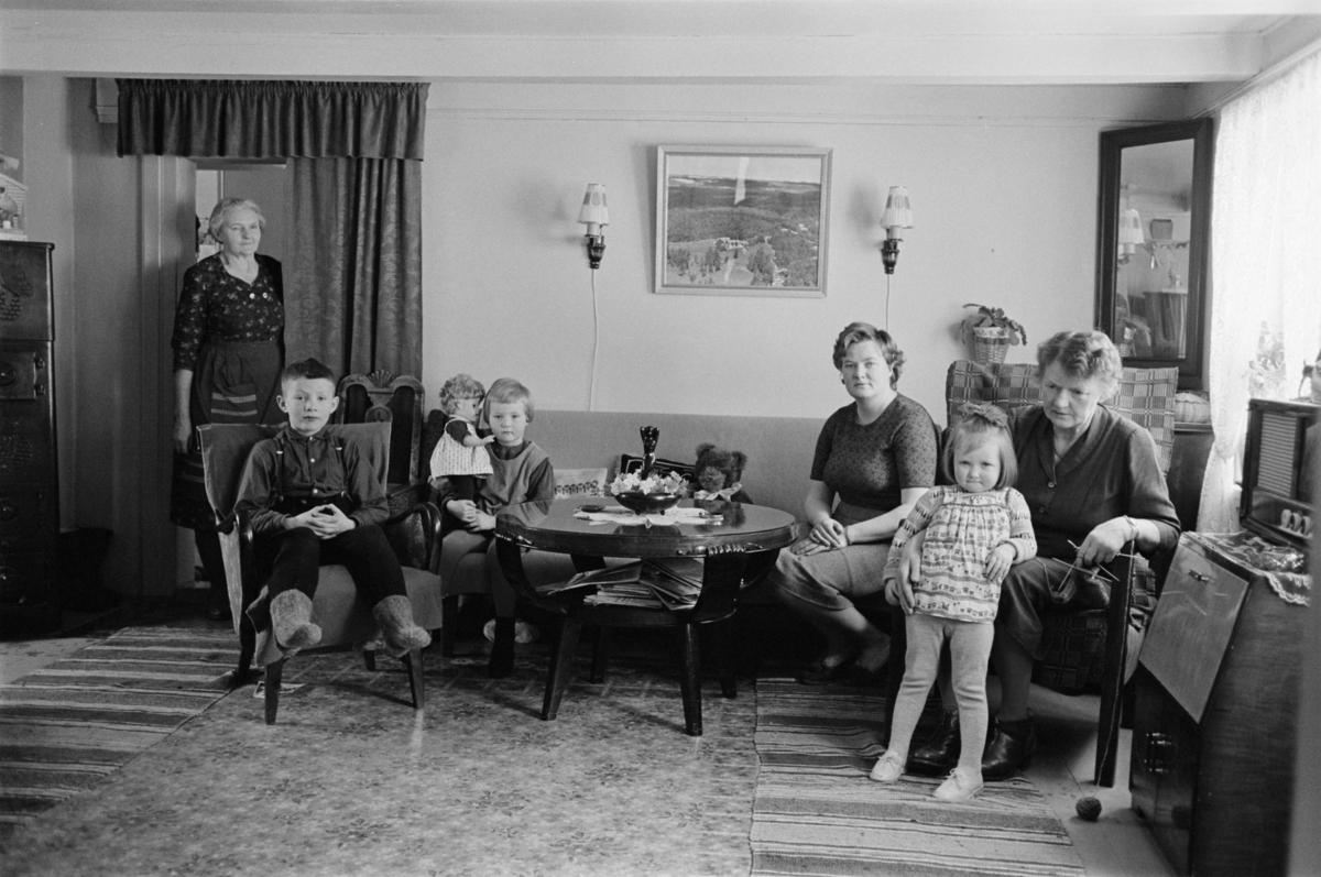 Barn og voksne sitter i en sofagruppe.