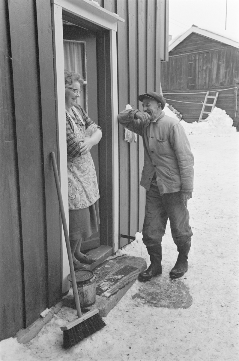 En kvinne og en mann står i en døråpning på Røros.
