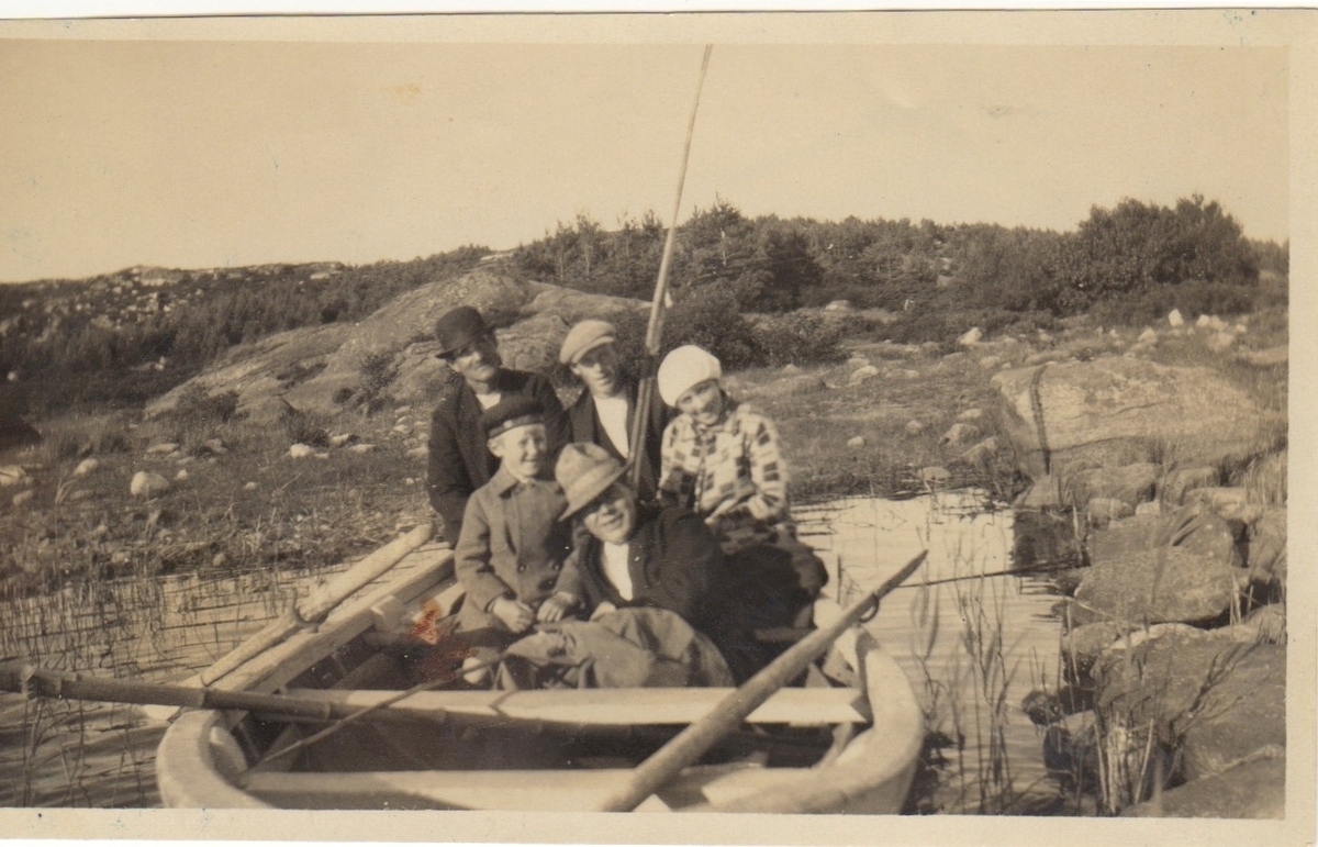 Fem personer sitter i en roddbå, Tutjärn i Labacka cirka 1930. Med i ekan är Axel och "Lisa" Johansson, Labacka 1:2 "Lund". Övriga är okända.
