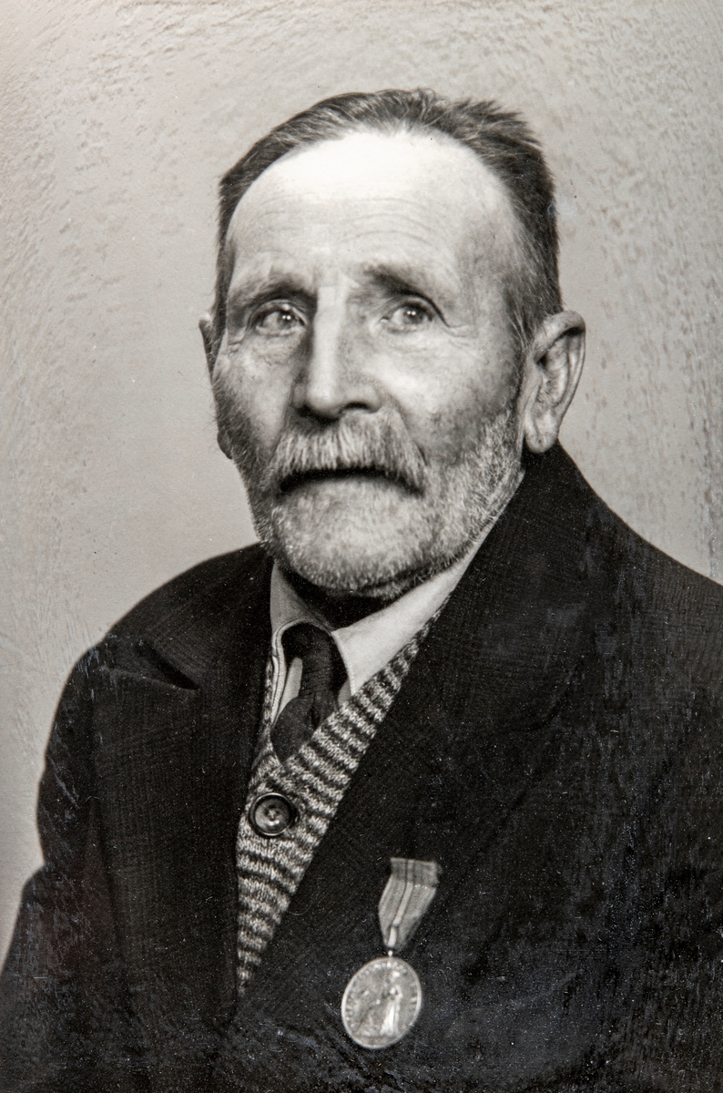 Portrett av  Nils Olsen Hagen på sin 90-års dag.  (født 29/1-1863, død 24/10-1955).
Han bodde i Hagen (Hvervenhagen) i Ottestad.