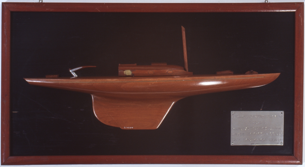 Halvmodell av skärgårdskryssaren TALATTA styrbords sida. En mast, ruff, två kappluckor och rorkult med beslag av vit metall. Skrov av polerat mahogny.Monterat på svart träplatta med brun ram.