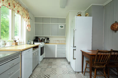Kjøkkeninteriør i grått, med brunt trebord