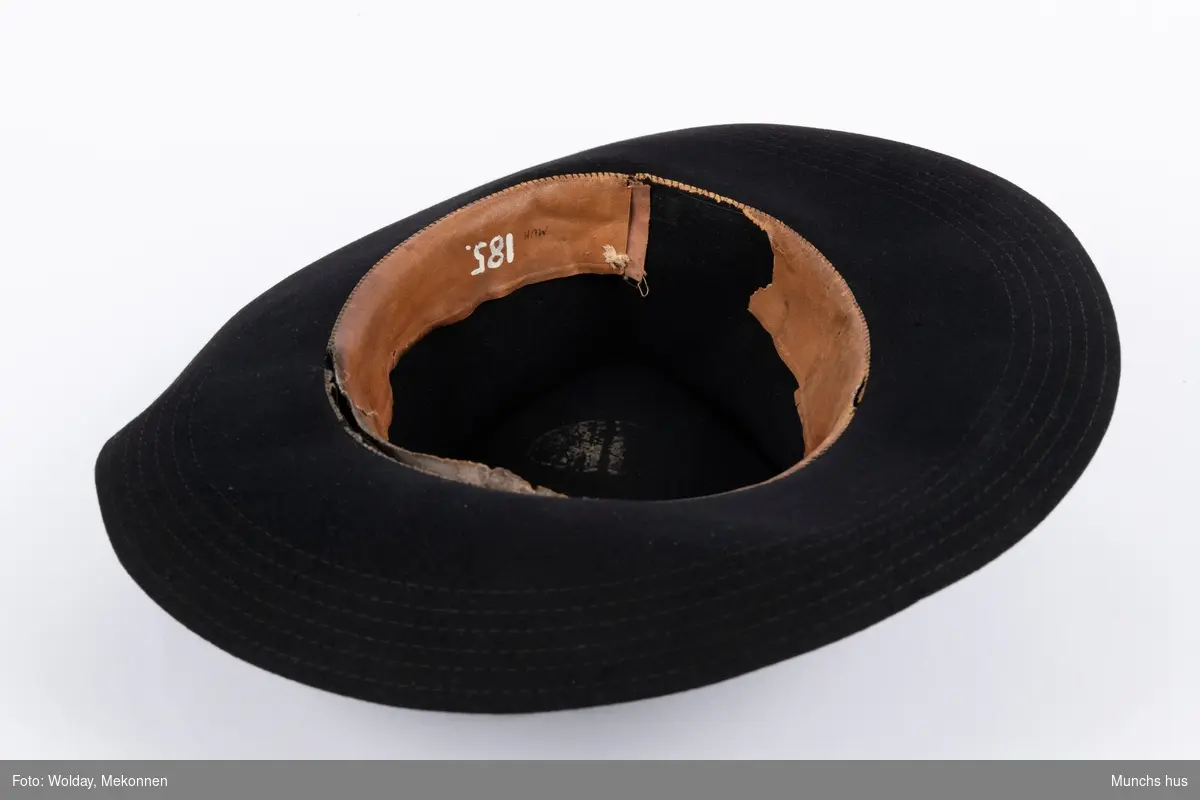 Sort hatt med brem (Gang). 
Laget i sort filt med silkebånd langs pull.