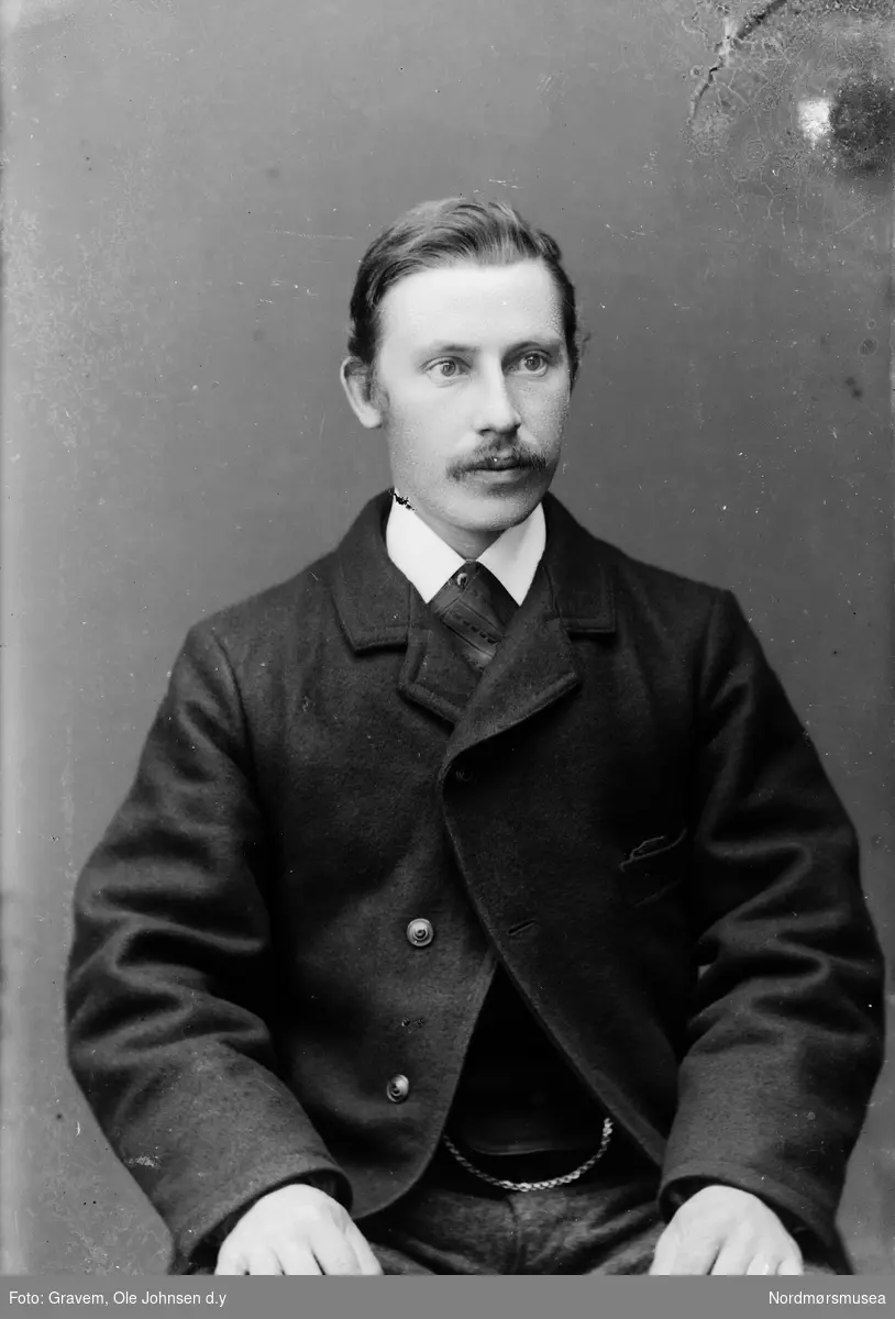 Halvportrett av mann med slips og bart. 
