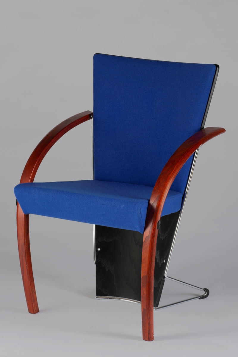Armstolen Collage har formbøyde armlener som går helt ned til gulvet i forkant og som danner stolens forben. Ryggbrettet smalner nedover og helt ned til gulvet og fungerer også som stolens bakben. Ryggbrettet har støtter i metall som går ut i bakkant på gulvnivå. Ryggbrettet er trukket i blått stoff ned til setet. Forøvrig er det lakkert svart. Setet er trukket i samme blåe stoff.
