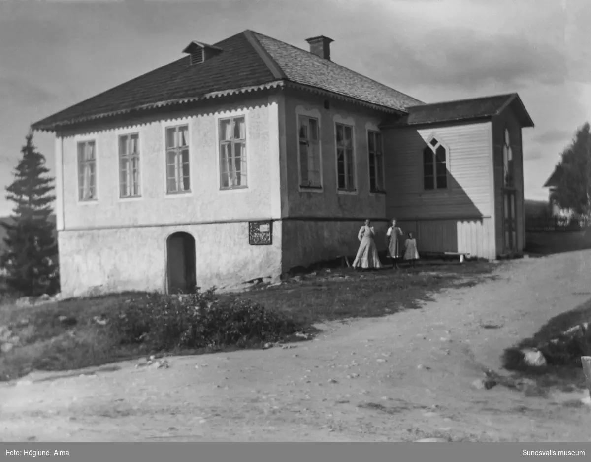 Två kvinnor och en flicka står framför det gamla kapellet i Fanbyn, Stöde, byggt 1876 med verksamhet fram till 1922. Byggnaden är numera riven.