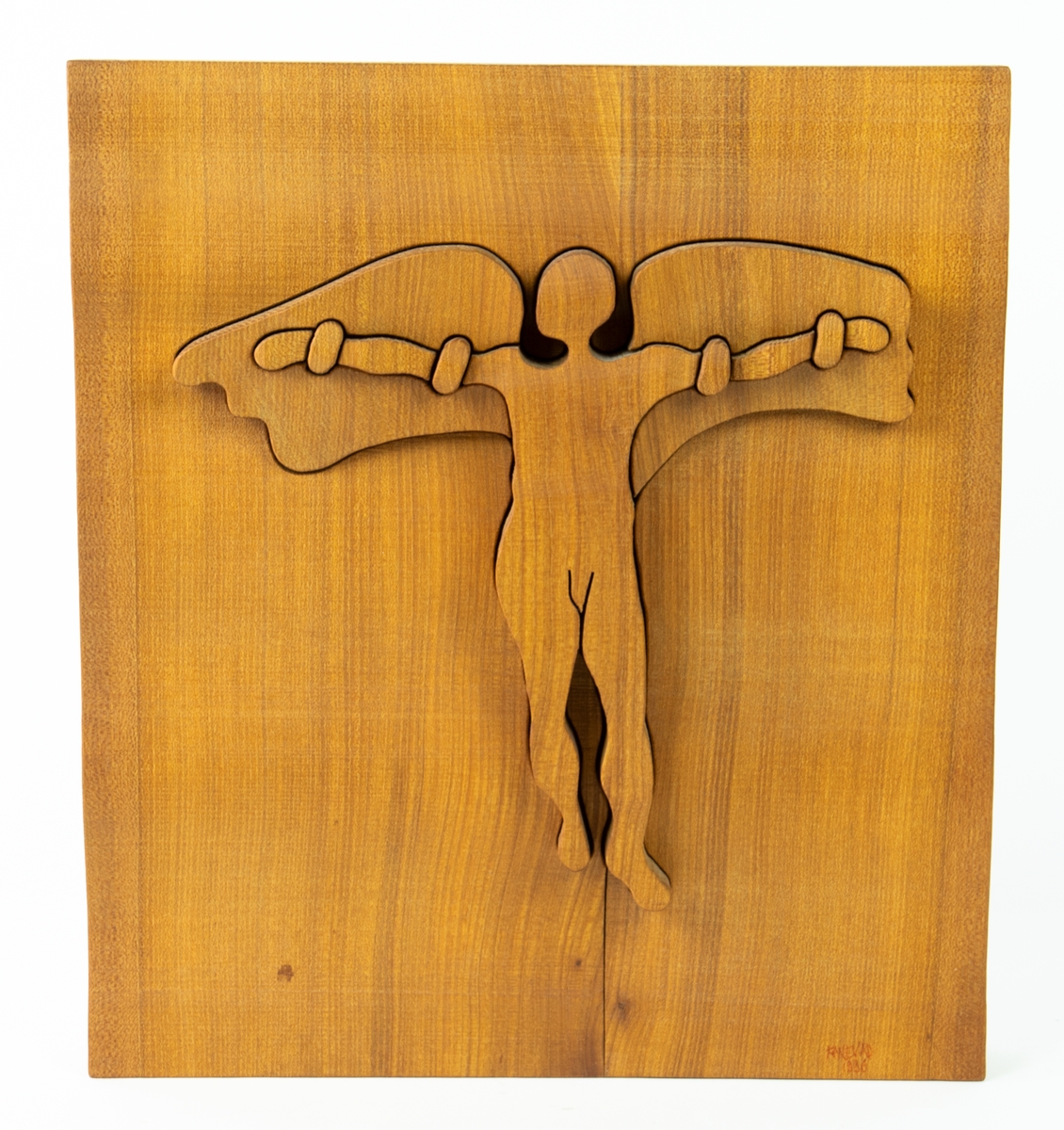 Skulptur/tavla, en relief utsågad i trä, föreställande en människa med vingar fästa på armarna, Ikaros. På baksidan en träfiberplatta med upphängningsanordning.