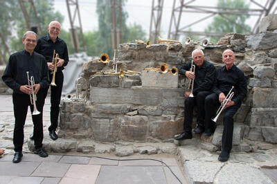 En søyleruin med trompeter omkranses av fire trompetister.. Foto/Photo