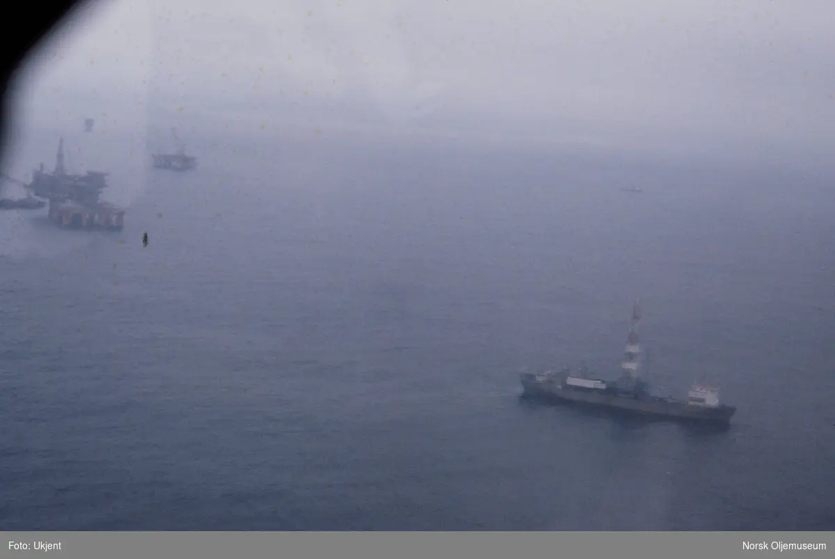 Flyfoto av en oljeplattform under bygging. I forgrunnen ligger et skip med et tårn.