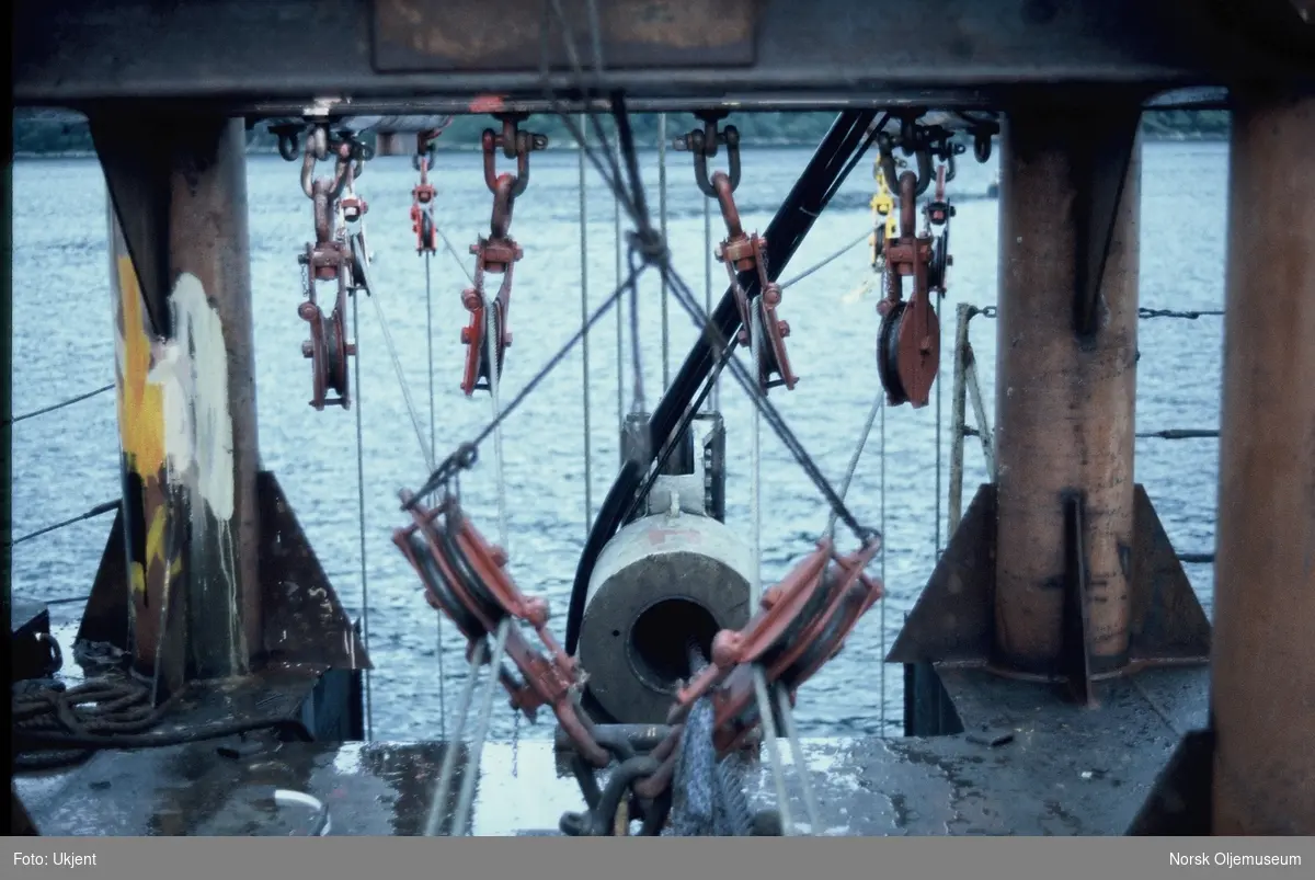 Løftesystem med taljer, bommer og vaiere for montering av et undervannsanlegg fra en båt eller lekter.