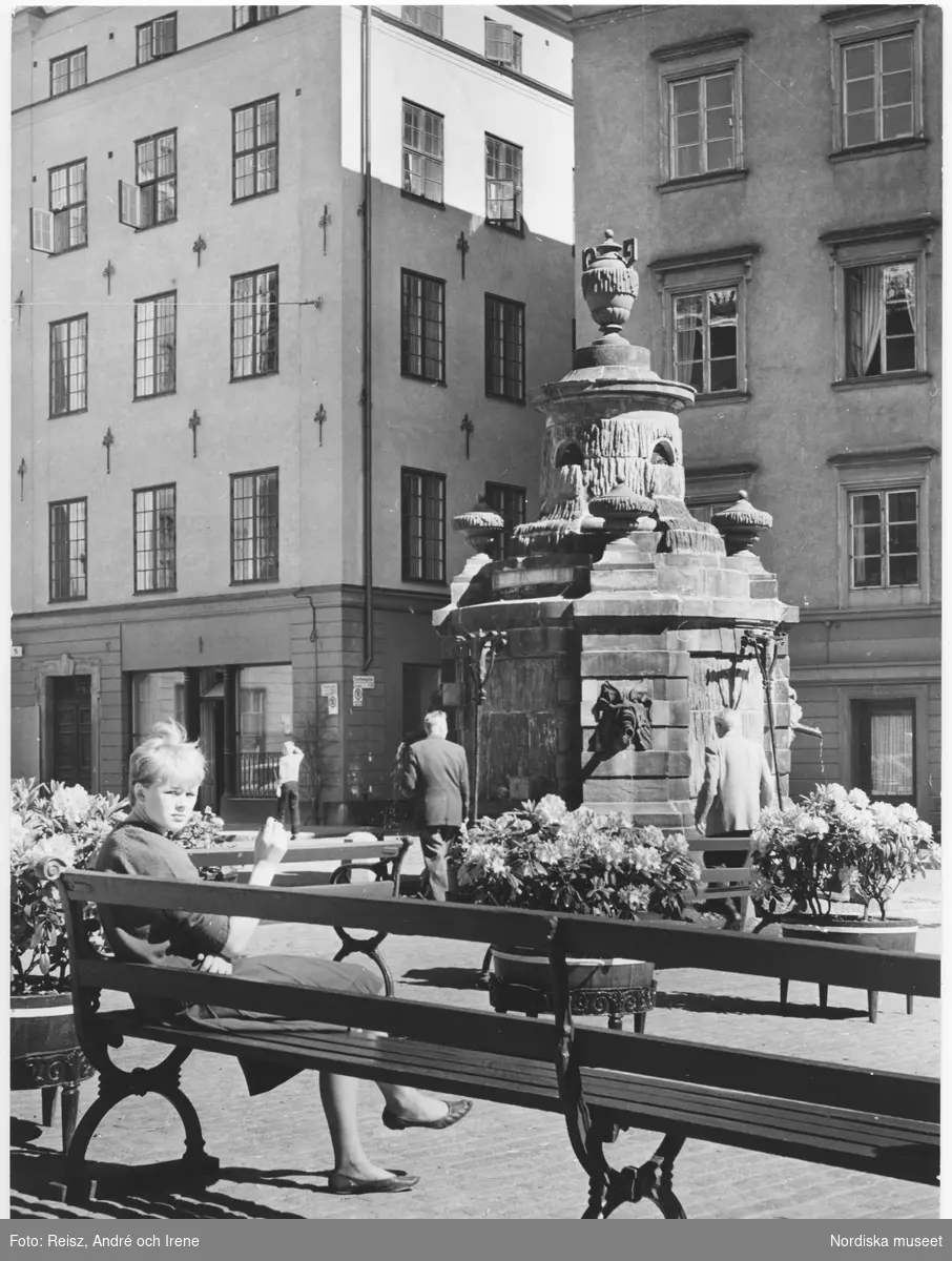 Stockholm. En ung kvinna sitter på en bänk på Stortorget i Gamla stan ...
