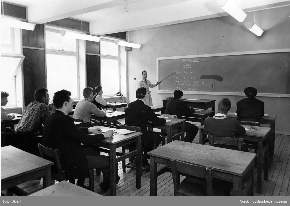 Rjukan Yrkesskole. Elever sittende i klasserom mens lærer underviser på tavlen.