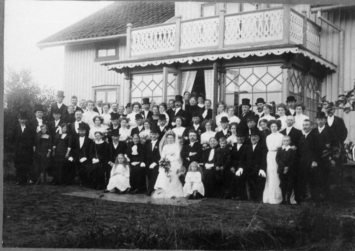 Släkt och vänner står samlade utanför Ekan 1:1 vid bröllopet mellan Amos Wessberg (född 1885 Torslanda/Gbg och Bohus) och Hildur Alm (född 1888 Ekan 1:1 Kållered, död 1971) 1911-10-07. Prästen hette Axel Sager.